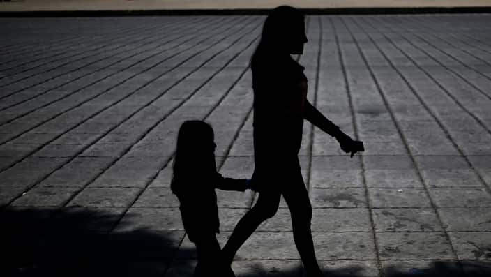 A woman and child walk during a march against human trafficking and slavery in Mexico City