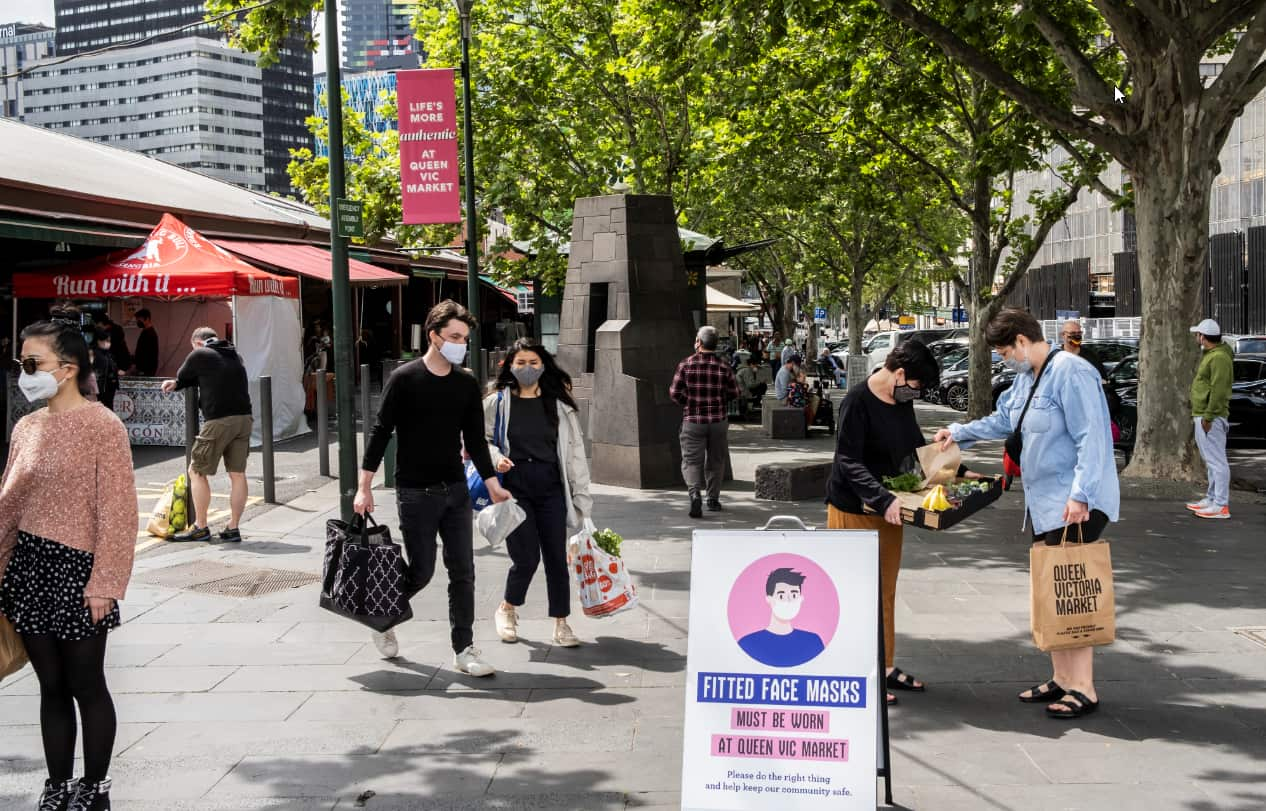 People wearing face masks observe social distance, after shopping at Queen Victoria Market, following Premier Daniel Andrews's announcement. 