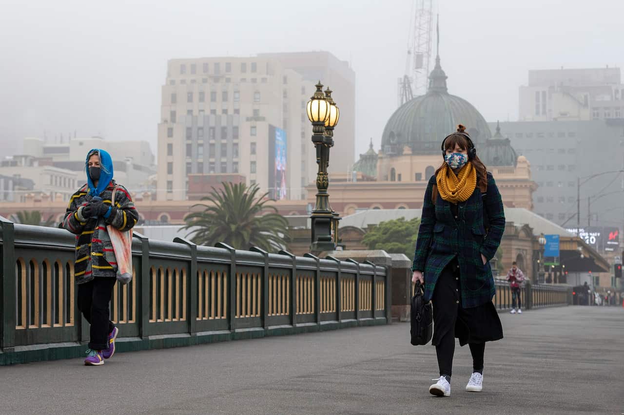 People are seen walking along the Princes Bridge in Melbourne, Friday, July 17, 2020. (AAP Image/Daniel Pockett) NO ARCHIVING