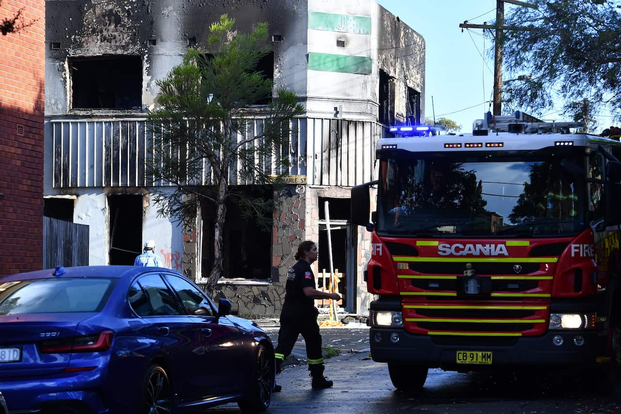 NSW Fire and Rescue officers at the scene of building fire in Newtown, Sydney, Tuesday, March 15, 2022. A person has died, five others are injured and some people are missing after a boarding house fire in Sydney's inner west suburb of Newtown. (AAP Image