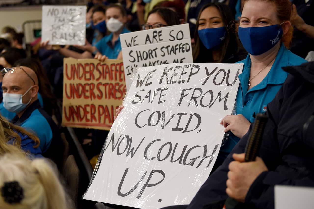 NSW heath workers hold placards during a strike by NSW Health workers in Sydney
