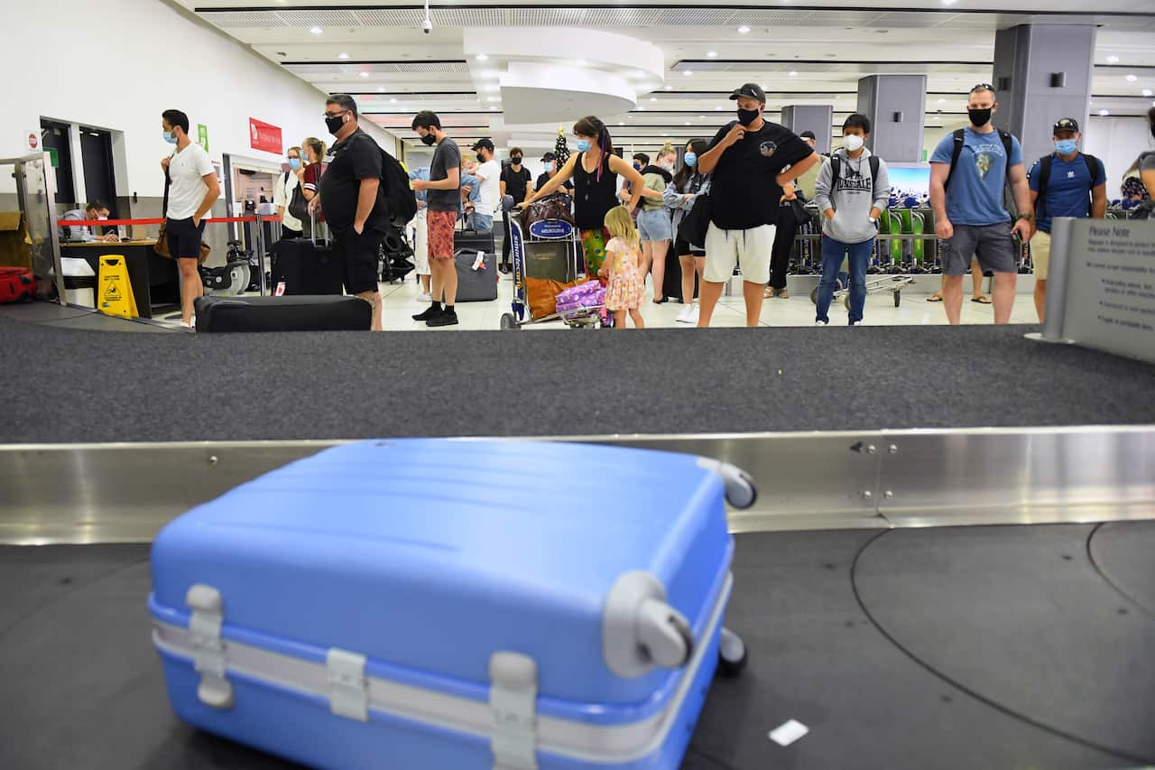 People are seen in the baggage collection area after arriving at Tullamarine Airport in Melbourne 