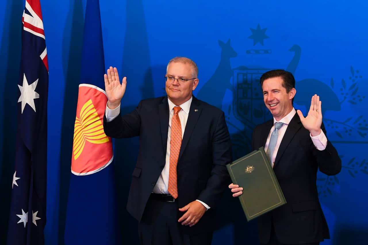 Australian Trade Minister Simon Birmingham (right) and Australian Prime Minister Scott Morrison react after signing  (RCEP)