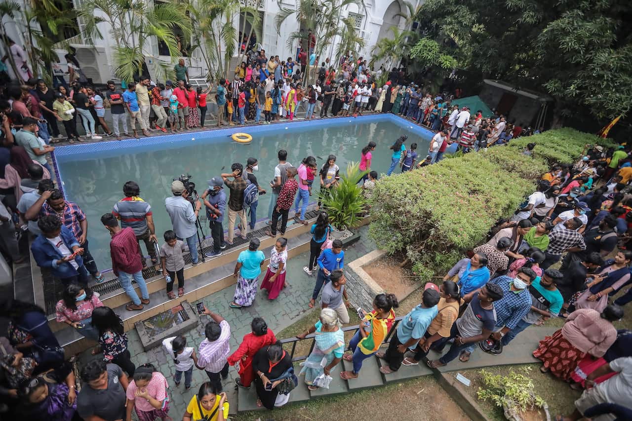 People take a look at and a dip in a swimming pool at the President's palace in Colombo, Sri Lanka