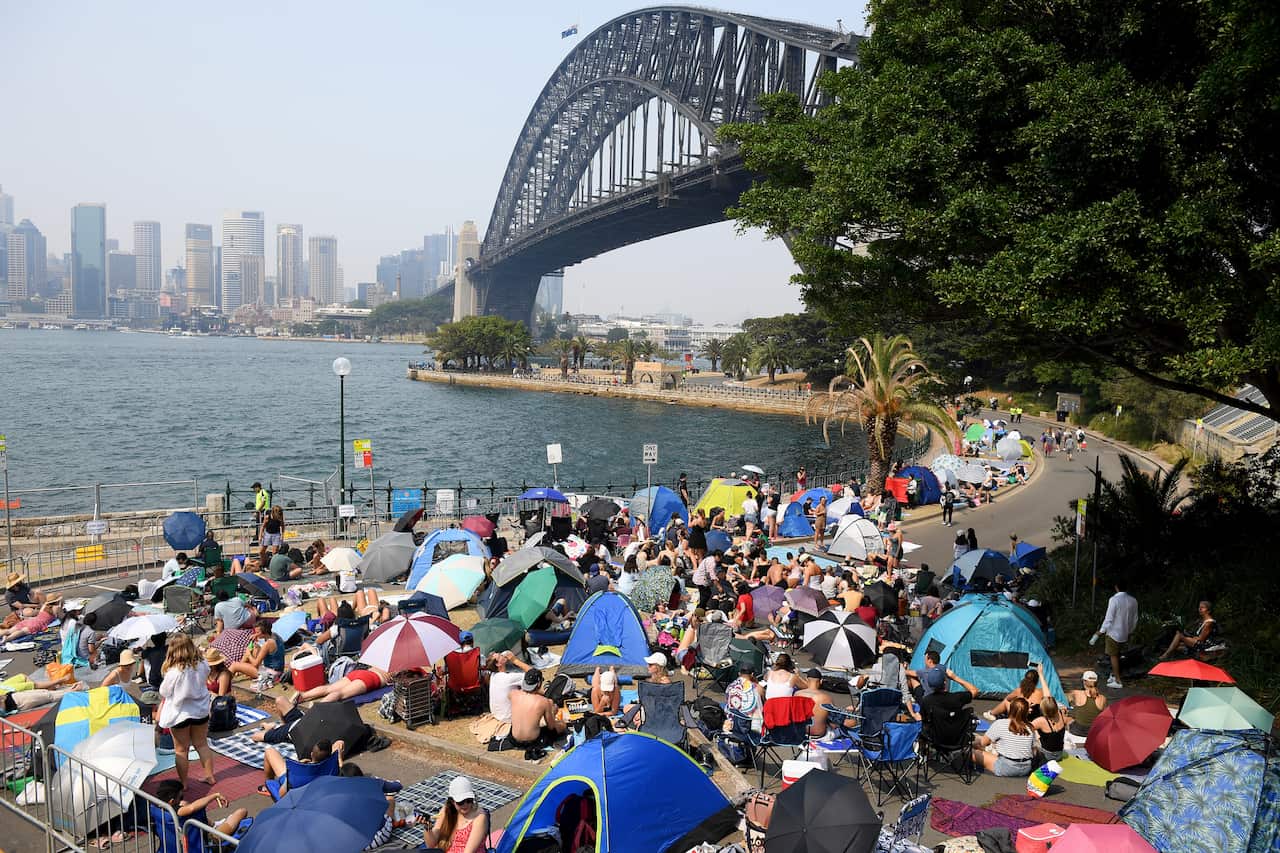 Revellers claim early harbourside positions at Kirribilli, ahead of the New Year's Eve fireworks, in Sydney, Tuesday, December 31, 2019