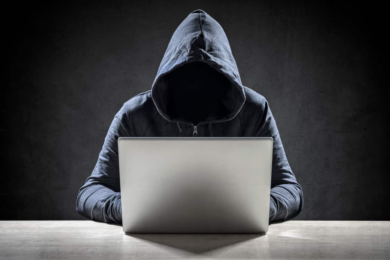 Computer hacker stealing data from a laptop