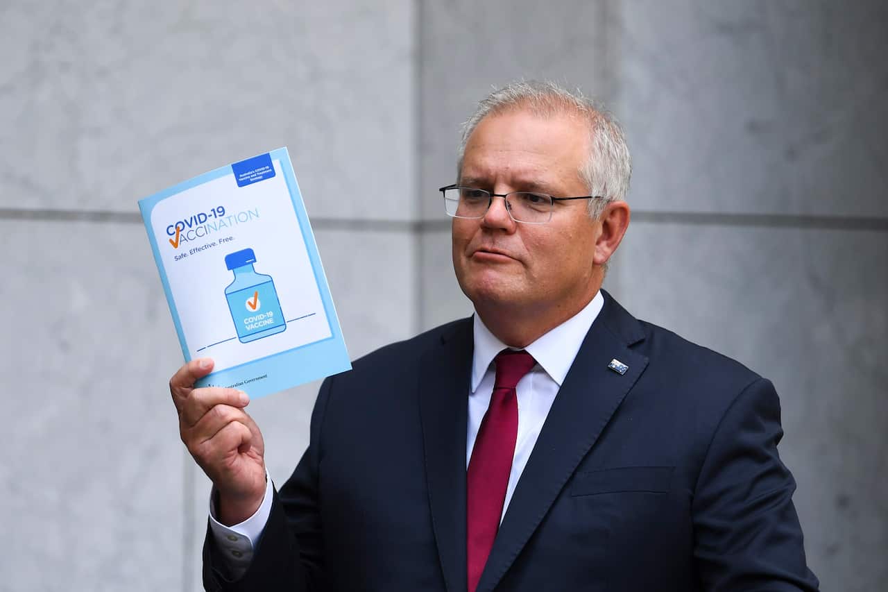 Australian Prime Minister Scott Morrison holds up a COVID19 vaccination leaflet as speaks to the media during a press conference at Parliament House in Canberra, Thursday, February 4, 2021. 