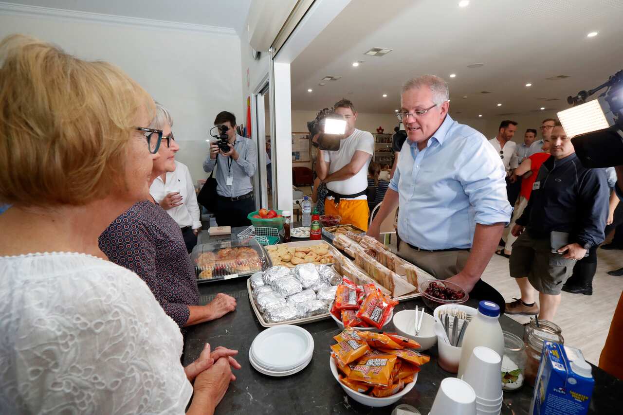 Prime Minister Scott Morrison speaks with volunteers while visiting the relief centre in Lobethal, South Australia, Tuesday, December 24, 2019. The Prime Minister is touring fire affected areas in South Australia. (AAP Image/Kelly Barnes) NO ARCHIVING