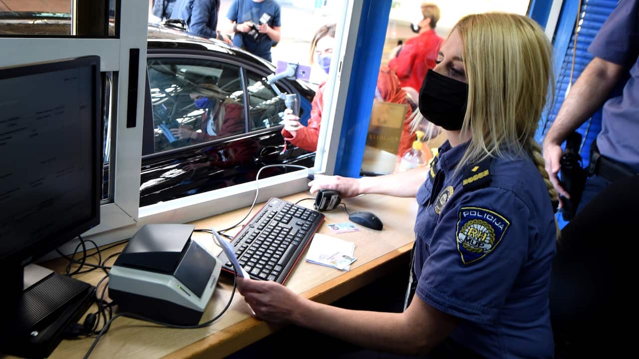 A Police officer checks a COVID-19 Green passport at the Bregana border between Croatia and Slovenia, 02 June 2021. From 02 June 2021, Croatia give to its citizens COVID-19 passports and also check other EU countries citizens passport with QR codes