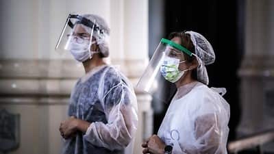 Nurses pray before applying vaccines against flu at a church in Buenos Aires, Argentina. 11 April 2020
