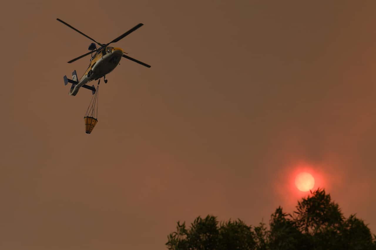 Water bombing aircraft battle the Green Wattle Creek Fire as it threatens homes in Yandeera in the south west of Sydney, Saturday, December 21, 2019. Temperatures in the 40's and high north westerly winds under extreme fire conditions are fanning a a numb