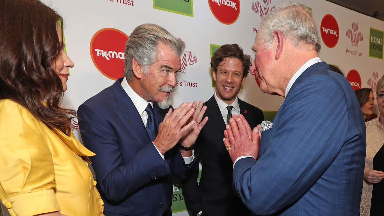 The Prince of Wales greets Pierce Brosnan (centre) with a Namaste gesture as he arrives at the annual Prince's Trust Awards 2020