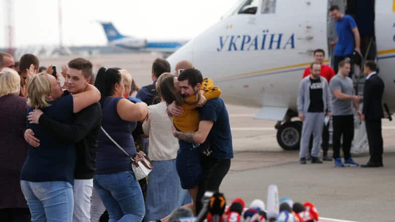 Planes carrying prisoners freed by Russia and Ukraine land in the countries' capitals.