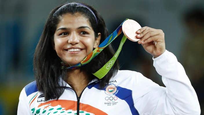 TOPSHOT - India's bronze medallist Sakshi Malik stands on the podium at the end of the women's 58kg freestyle wrestling event at the Carioca Arena 2 in Rio de Janeiro on August 17, 2016, during the Rio 2016 Olympic Games.
