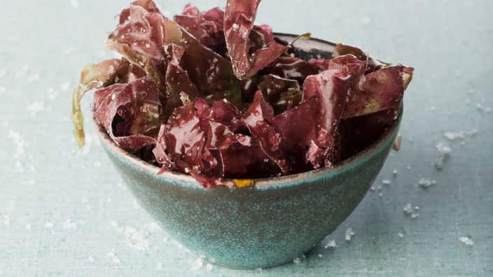 Bowl of seaweed, chopsticks picking up piece