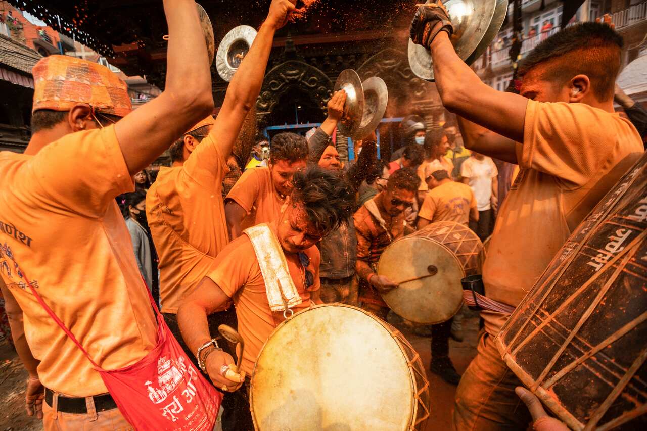 Peoples from the Newari community play traditional instruments while throwing vermilion Powder (Sindoor) to each other during the Sindoor Jatra festival.Revelers carried chariots of the Hindu gods and goddesses and hurled vermillion powder onto each other