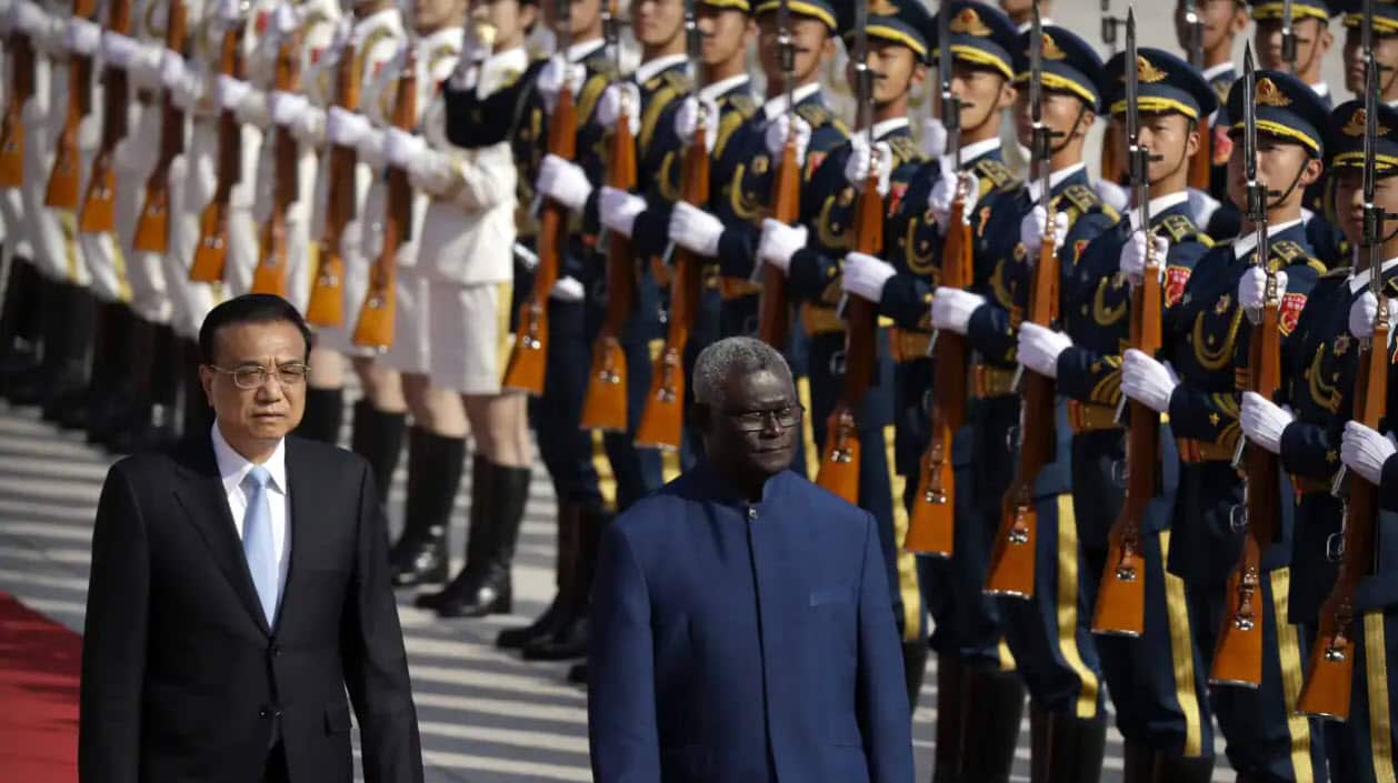 نخست‌وزیر چین لی کِچیانگ (چپ) در کنار نخست‌وزیر جزایر سلیمان مناسه سوگواره در حال رد شدن از جلو گارد افتخاری در تالار بزرگ مردم پکن، ۹ اکتبر ۲۰۱۹.