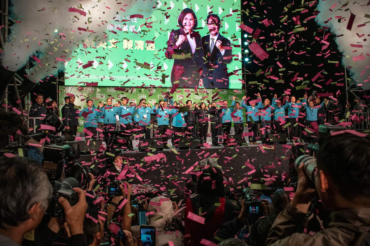 Confetti falls as Tsai Ing-Wen (C) holds hands with Vice President-elect William Lai (C-L) and Vice-President, Chen Chien-jen (C-R).