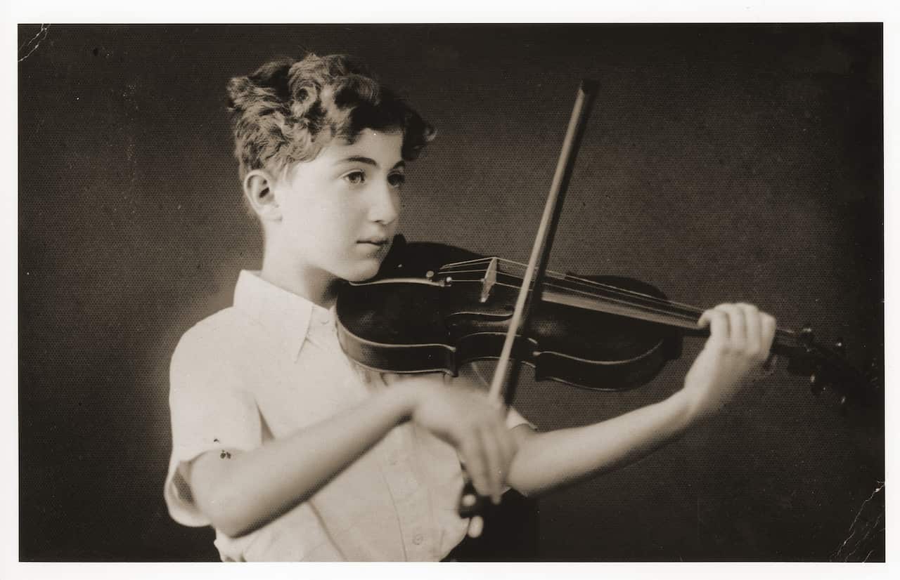 The eleven-year-old German Jewish refugee, Helmut Stern, practices the violin in his home in Harbin, China. 1939