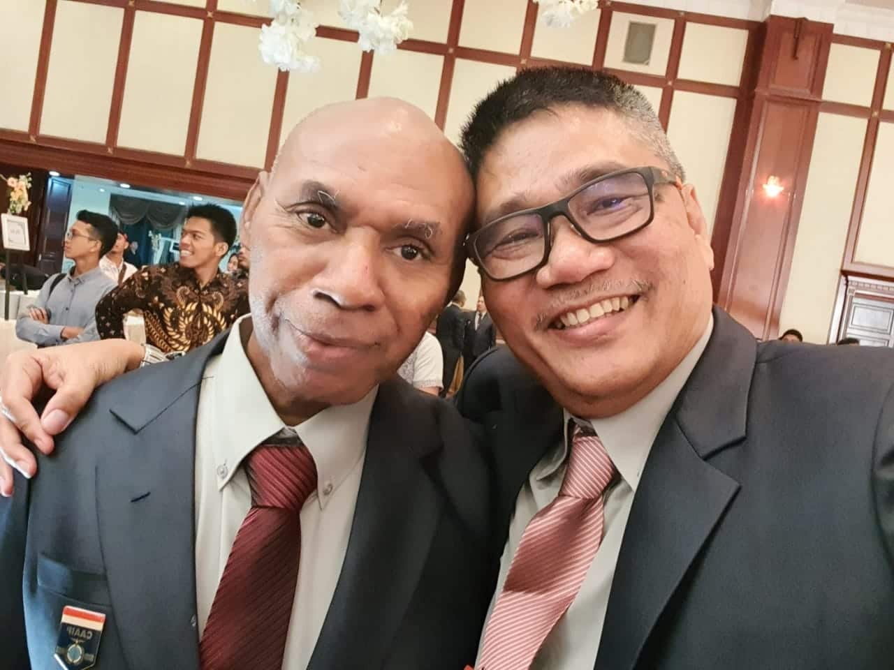 Timotius (left) and old student colleague Abraham Pontoh, celebrate the marriage of a friend’s child.   