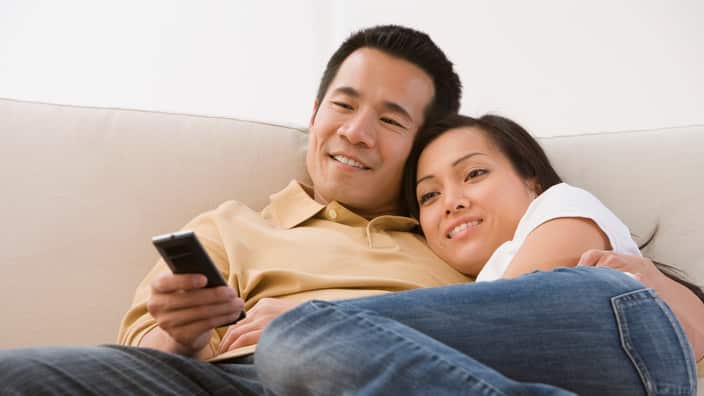 Asian couple watching television