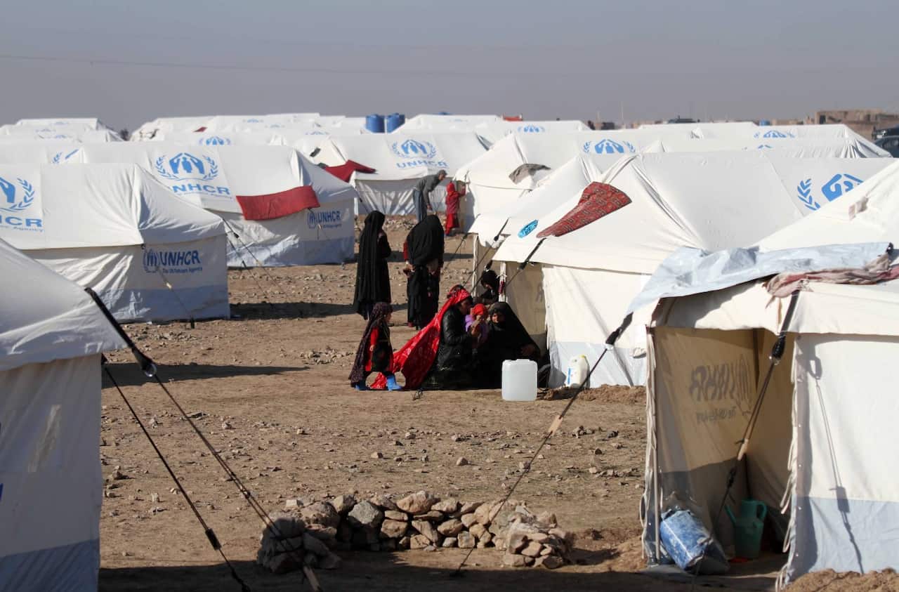 Afghan Internally Displaced persons sit near tents at their temporary shelters built by United Nations High Commissioner for Refugees in Herat.