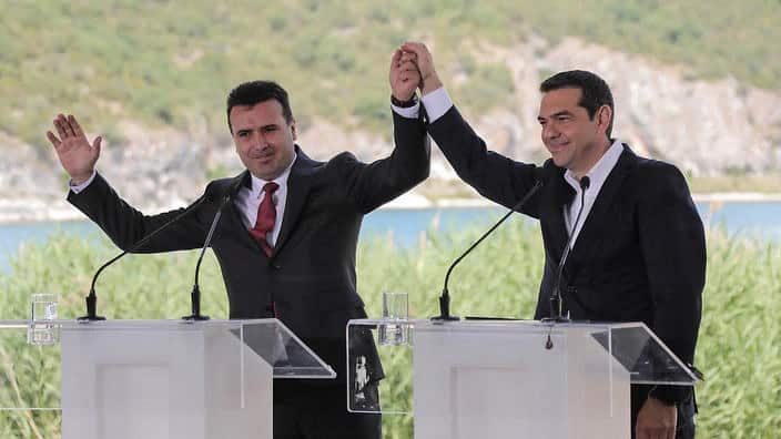 Greek Prime Minister Alexis Tsipras, right and his FYROM counterpart Zoran Zaev, raise their hands during the signing of the Prespa Agreement.