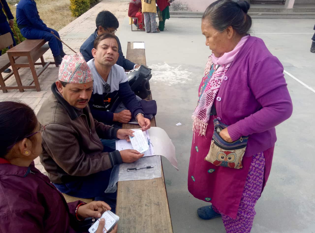 A Nepali woman receives her voter identification card from officials in Kathmandu.