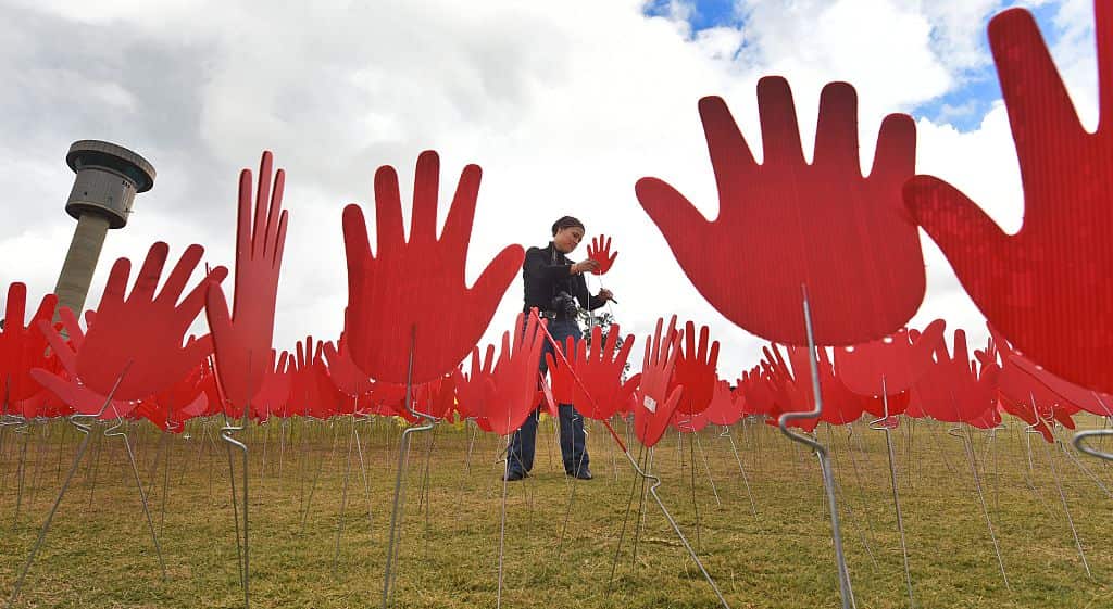 An artist at an art installation in Aboriginal colours.
