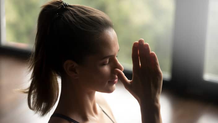 Young sporty woman in Alternate Nostril Breathing