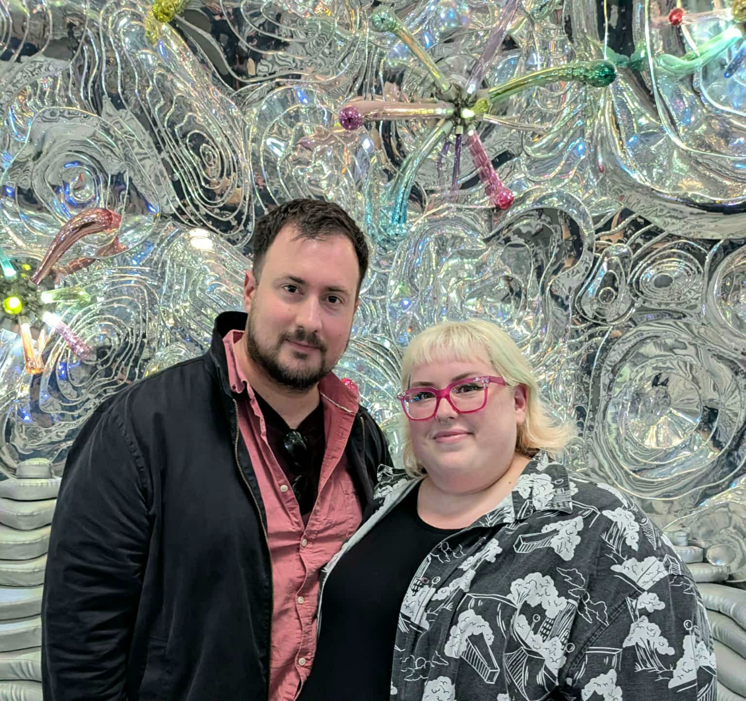 A couple standing in front of a swirly art installation.