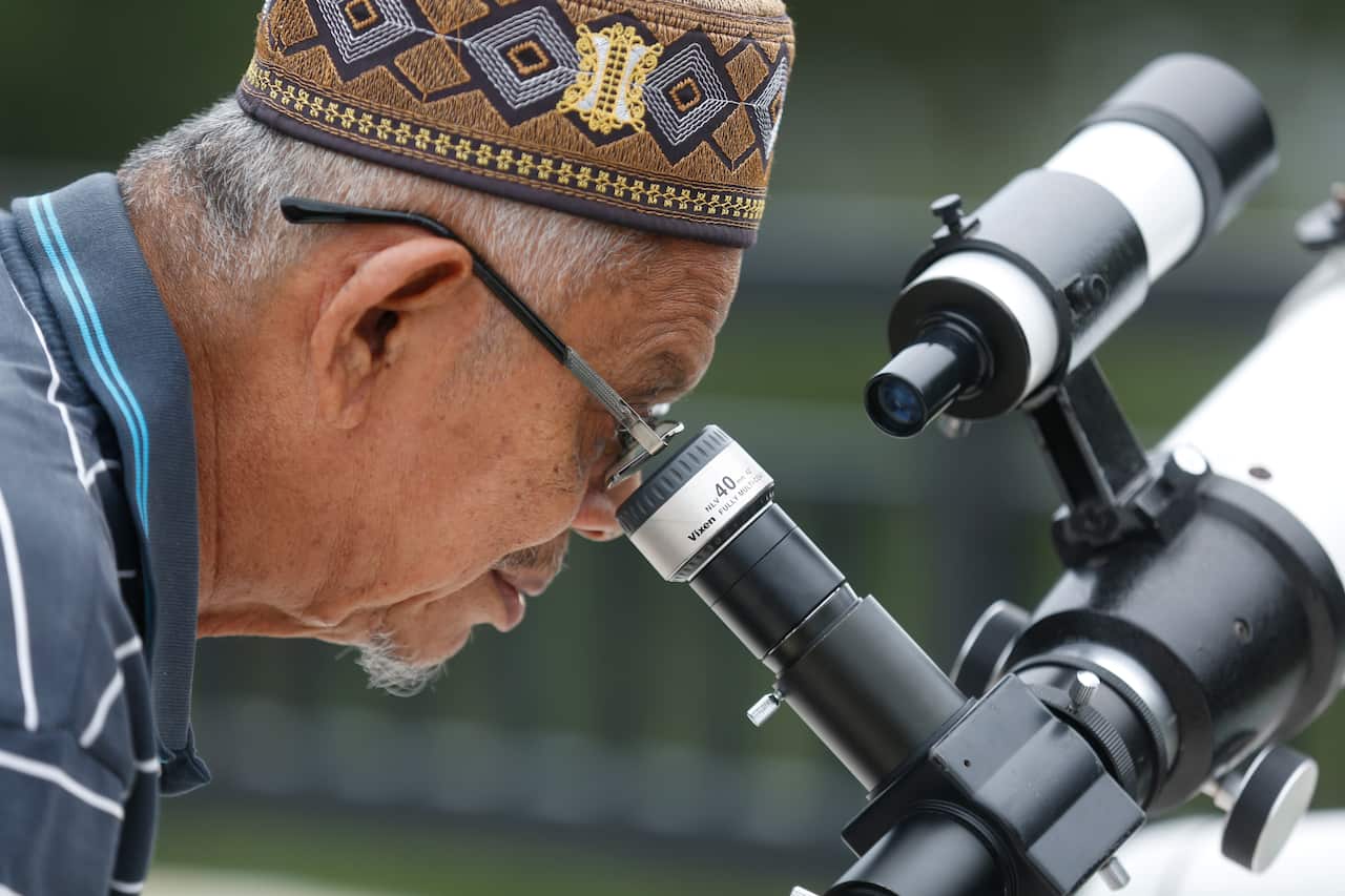 A man uses a telescope to observe the position of the moon to determine the start of Islamic holy month of Ramadan in Indonesia.
