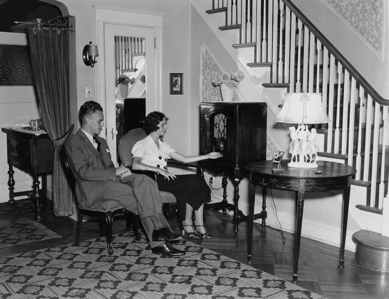 Mid adult couple listening to radio in living room