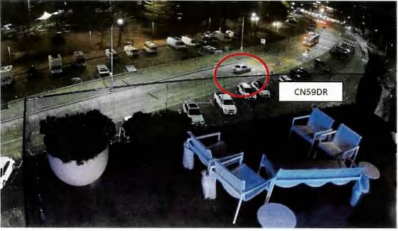 Vista aérea de un automóvil conduciendo por una carretera por la noche. El coche está rodeado de rojo.