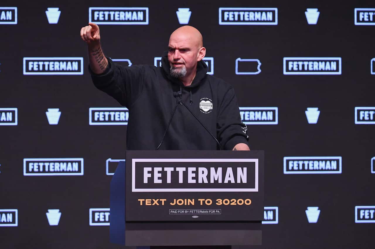A man standing at a podium in front of microphones.