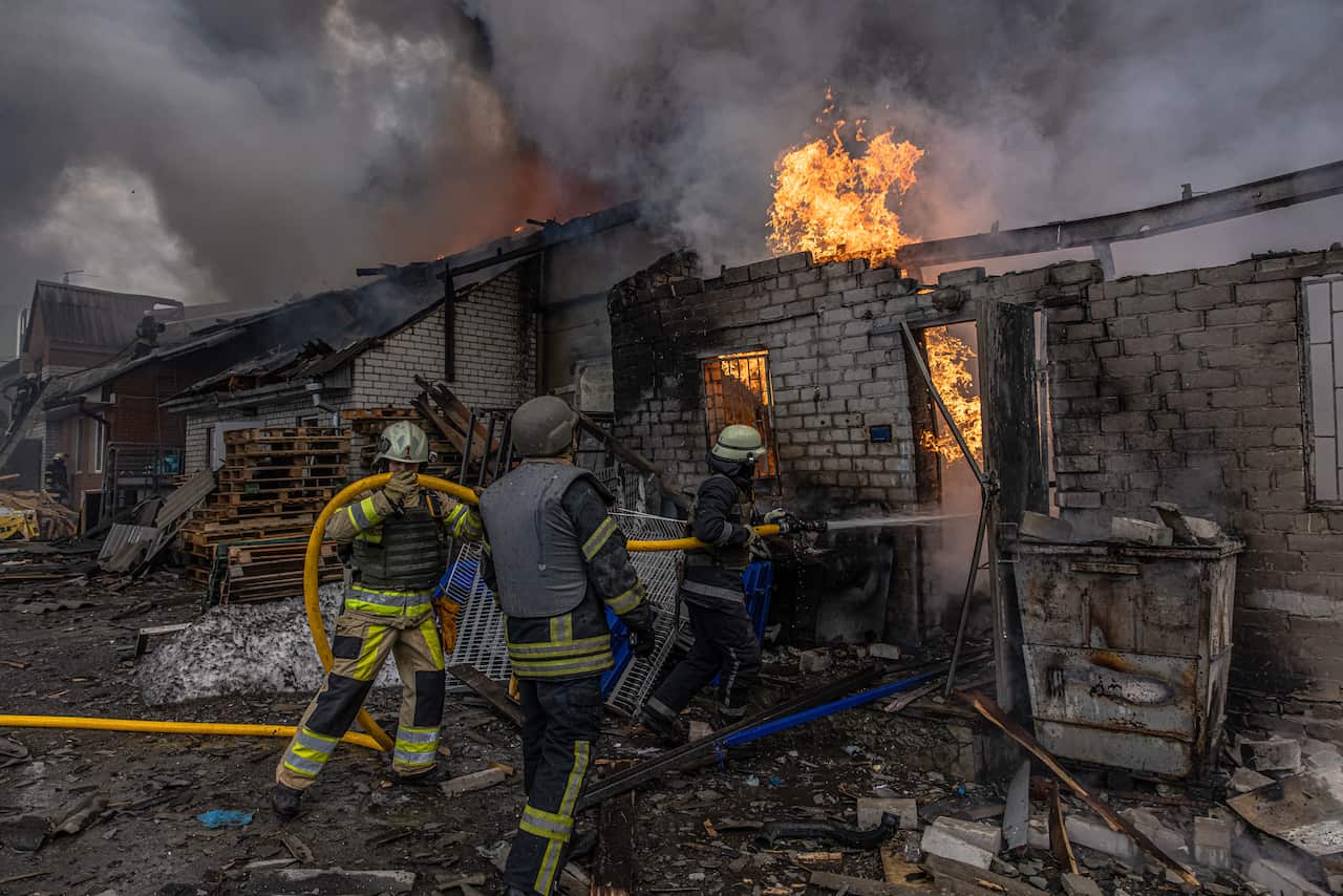 Firefighters are seen trying to extinguish a fire at a warehouse.