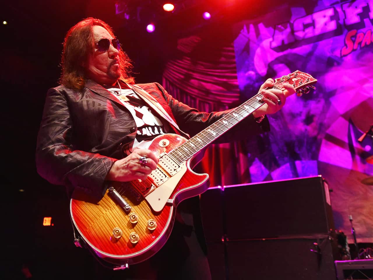 A guitar player performs on a stage.