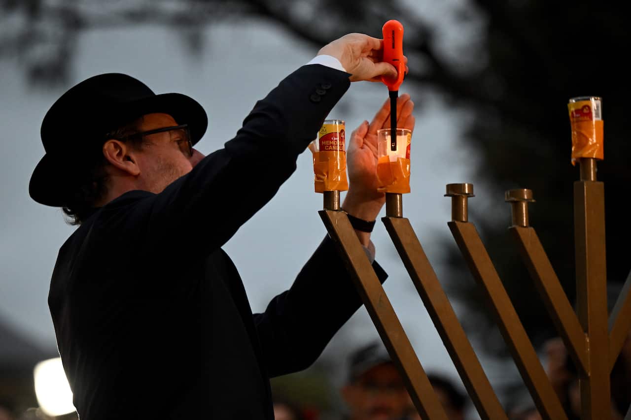 A Rabbi lights a Menorah during a vigil in Bondi Beach, Sydney.
