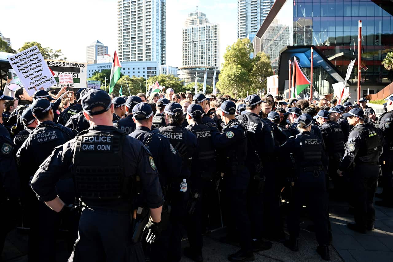 Riot police officers stand in front of protesters at an attempted blockade