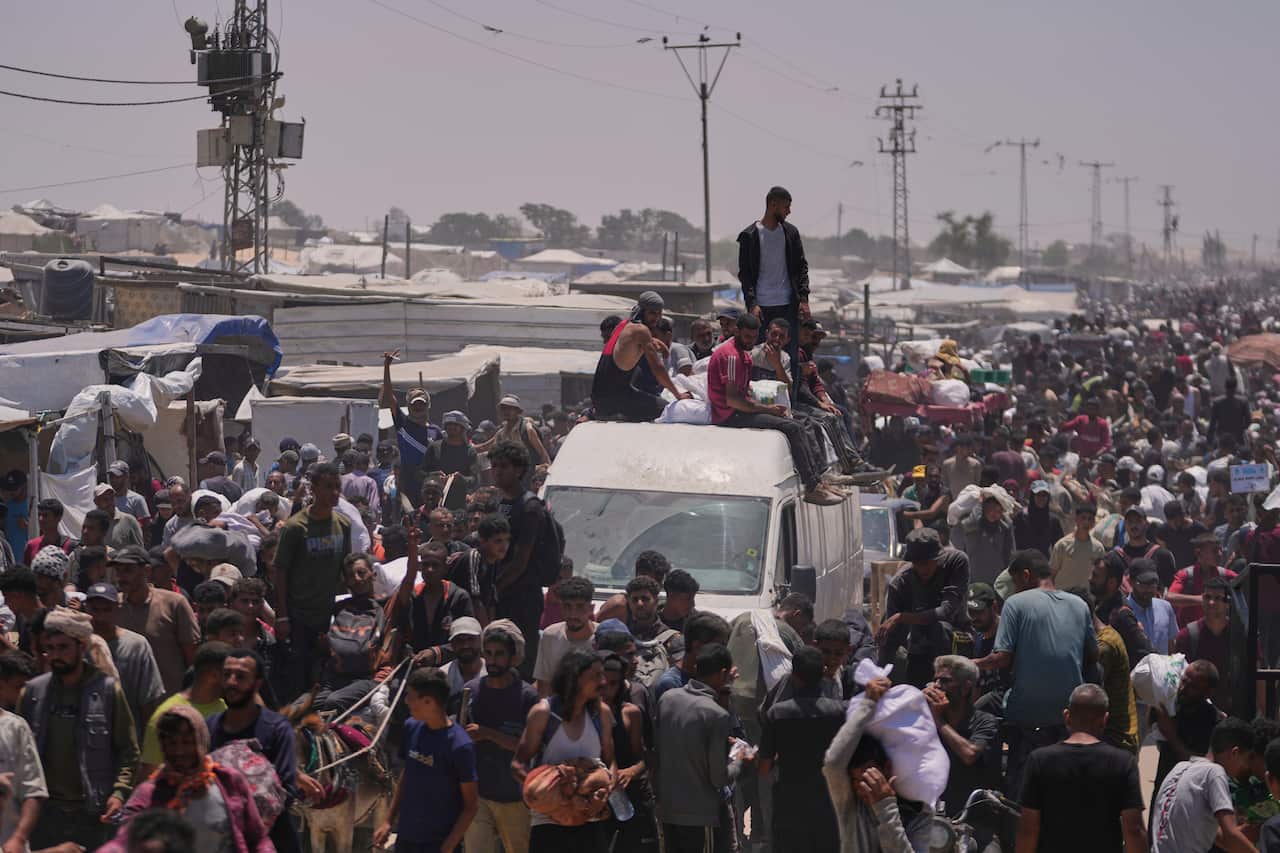 Palestinians carry bags of food and humanitarian aid.