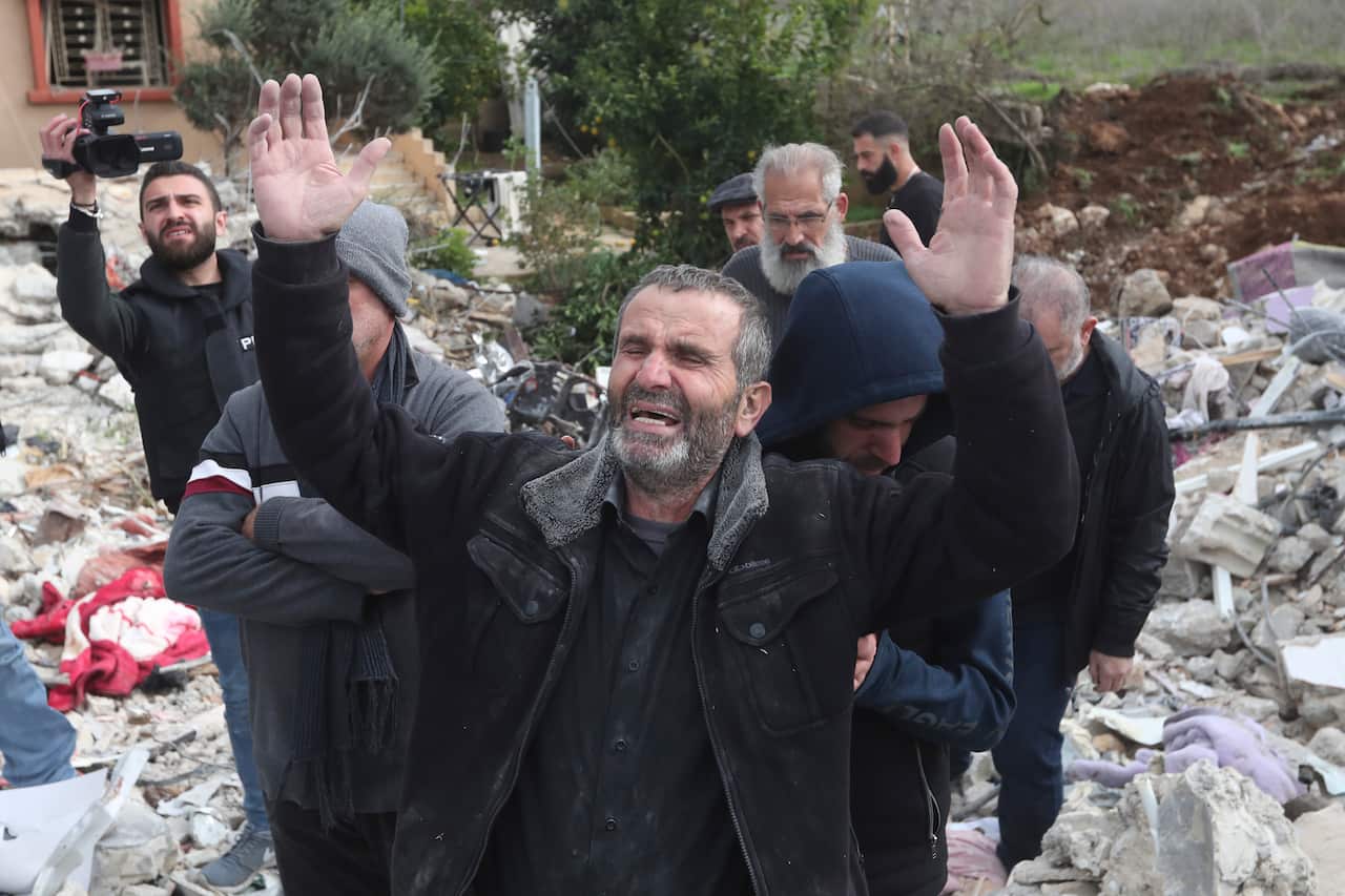 A man is seen crying amidst the rubble following an air strike.