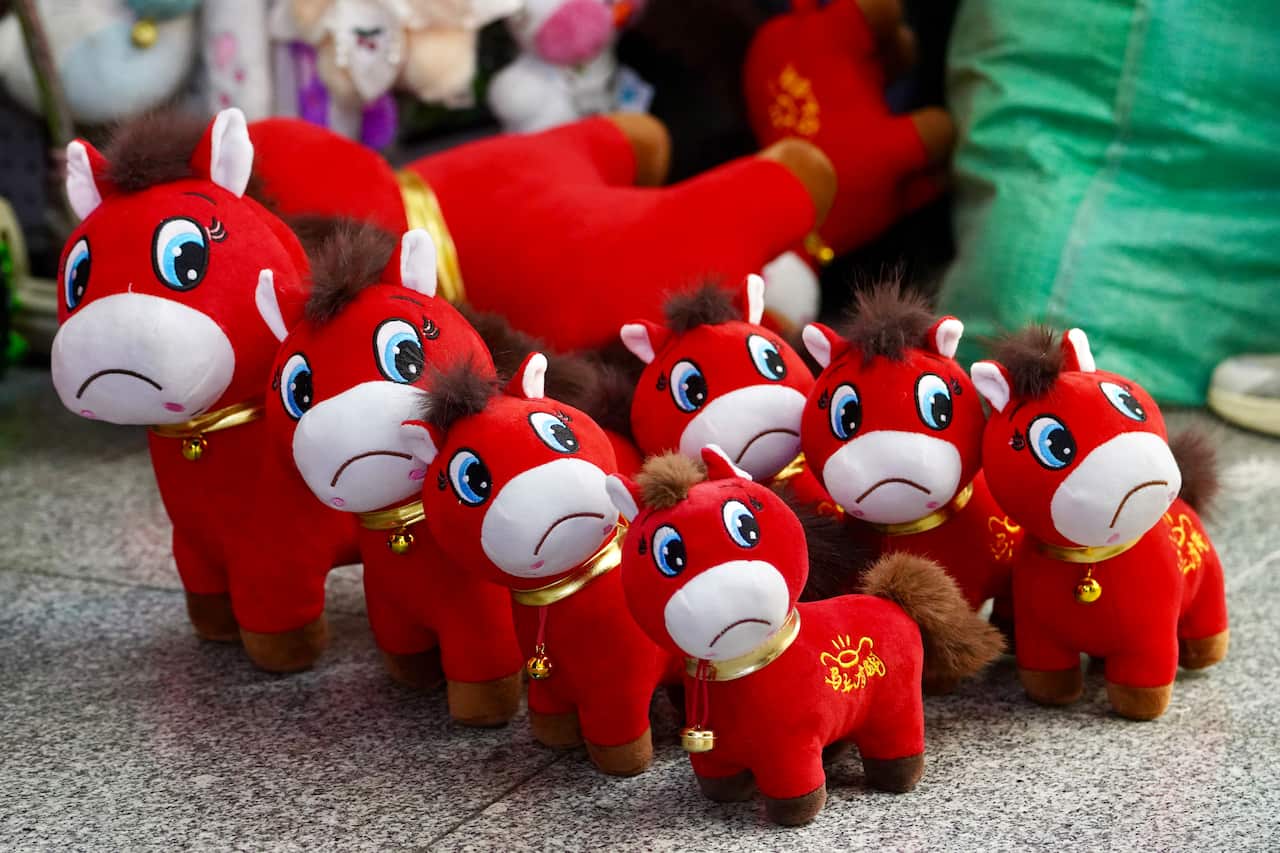 A group of red horse toys with smiles stitched on upside down 