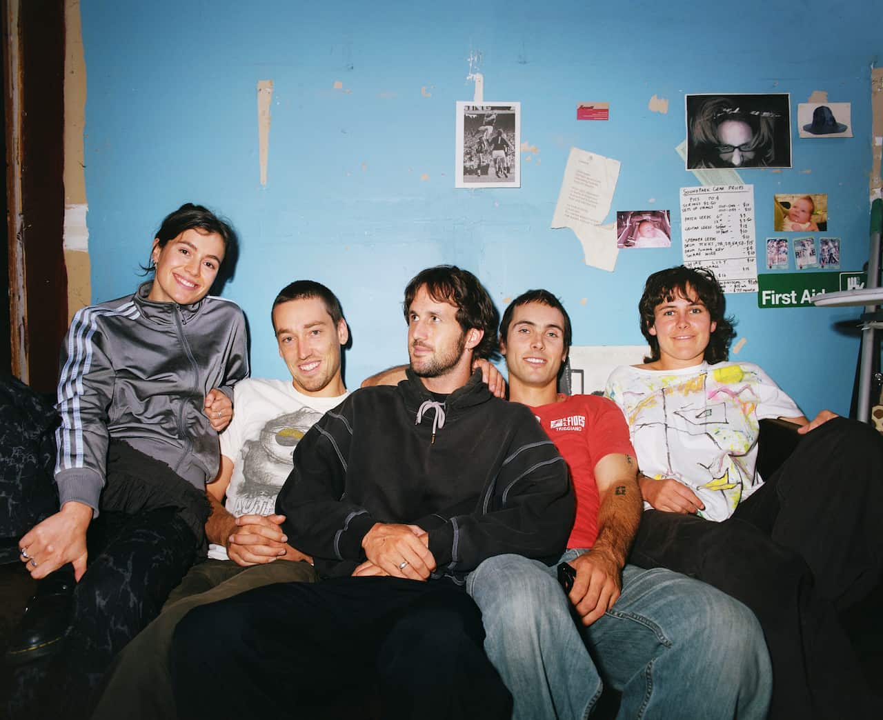 A group of people sitting down and smiling at a camera.