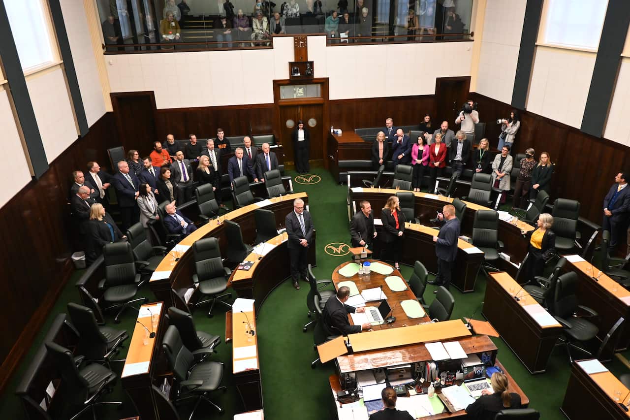 A group of politicians standing on either side of parliament.